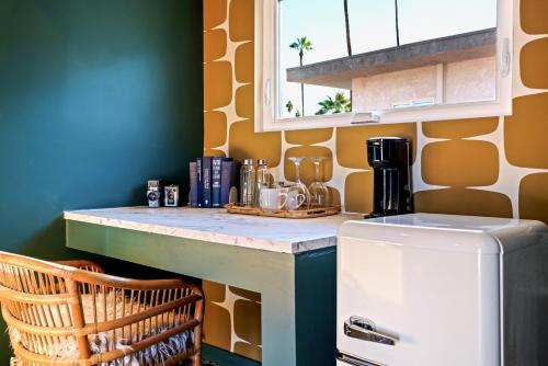 a small kitchen with a counter and a refrigerator at The Stardust Hotel - Adults Only in Palm Springs