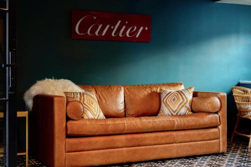 a brown leather couch sitting in a living room at The Stardust Hotel - Adults Only in Palm Springs