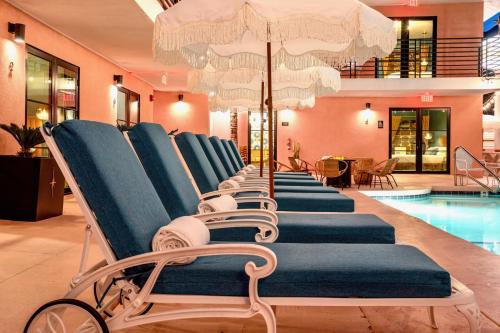 a row of lounge chairs in a swimming pool at The Stardust Hotel - Adults Only in Palm Springs