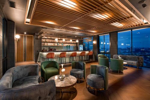 a bar with couches and a table and chairs at The Manohara Hotel Yogyakarta in Yogyakarta