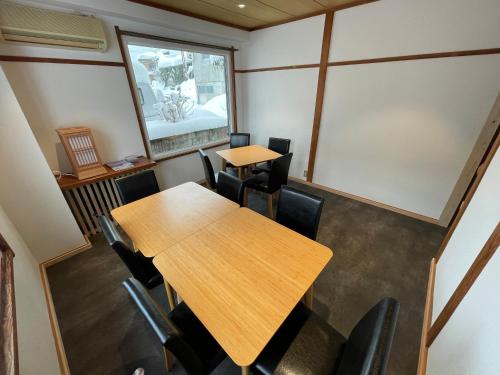 a conference room with two tables and chairs at Chohachisou Lodge in Nozawa Onsen