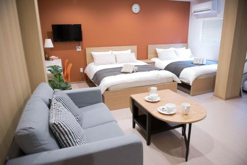 a hotel room with two beds and a couch at valuehjq VALUE NAMBA SOUTH III in Osaka