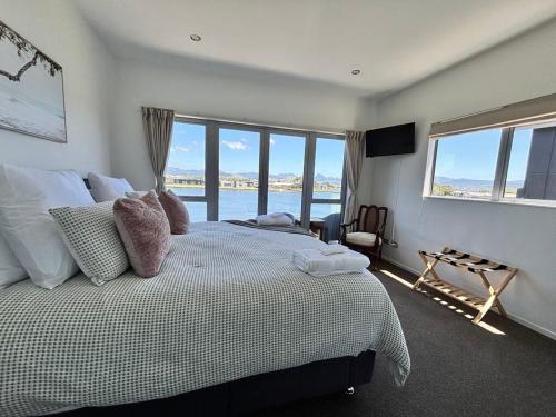 a bedroom with a bed with a view of the ocean at Charming Lakeview Golf Villa in Matarangi