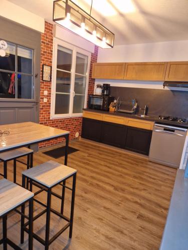 - une grande cuisine avec du parquet, des tables et des comptoirs dans l'établissement La Belle Evasion, à Gamaches