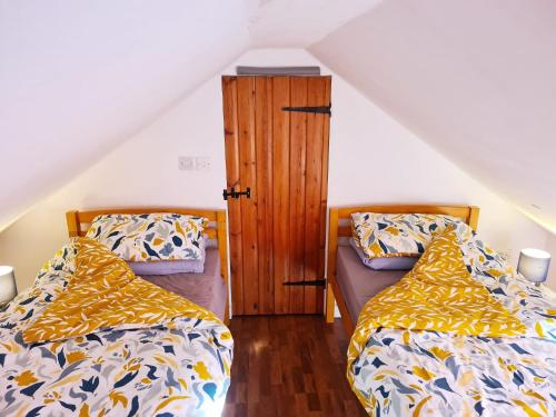 a bedroom with two beds and a wooden cabinet at East of Ipswich Bed and Breakfast - Private & Dorm Rooms Suffolk in Ipswich