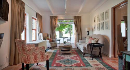 a living room with a couch and chairs at Klein Welmoed Luxury Guest House in Stellenbosch