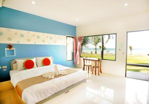 a bedroom with a large bed with a blue wall at Burapabeach บูรพาบีช ติดทะเล in Ban Khlong Khut