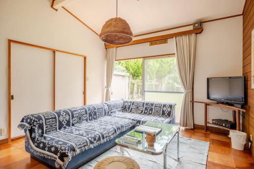 a living room with a couch and a tv at KIKA STAY - 10sec Yumigahama Beach 3bed rooms 弓ヶ浜ビーチの目の前 BBQ可能 in Minamiizu