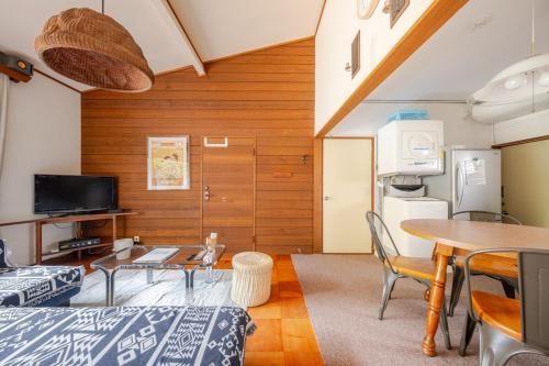 a room with a table and chairs and a tv at KIKA STAY - 10sec Yumigahama Beach 3bed rooms 弓ヶ浜ビーチの目の前 BBQ可能 in Minamiizu