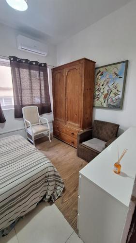 a bedroom with a bed and a chair and a cabinet at Central Apartament 4b near to seafront Ta Xbiex in Taʼ Xbiex