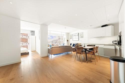 a kitchen and living room with a couch and a table at Spacious 3-bedroom with stunning Battersea views in London