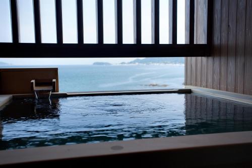 a swimming pool with a view of the ocean at Hanagoyomi in Sumoto