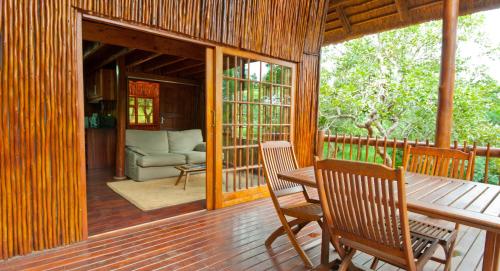 a porch of a house with a table and chairs at Amafu Forest Lodge in Hoedspruit