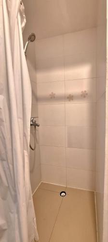 a shower with a white shower curtain in a bathroom at Central Apartament 4b near to seafront Ta Xbiex in Taʼ Xbiex