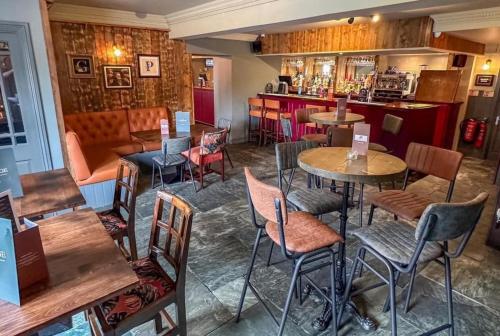 a restaurant with tables and chairs and a bar at The George Inn Plympton in Plymouth