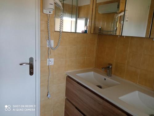 une salle de bain avec un lavabo et un miroir dans l'établissement les bleuets, à Sainte-Marie-la-Mer