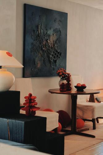 a living room with a table and chairs and a painting at Dali Shuanglang Anqi'erhai Resort Hotel in Dali Shuanglang