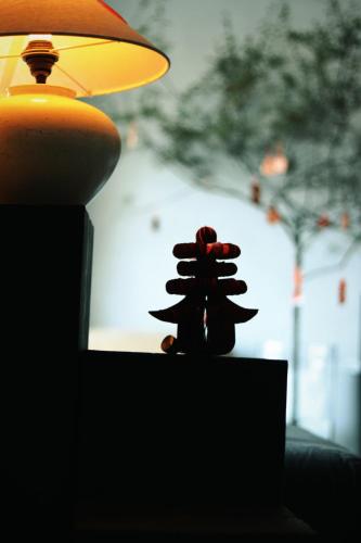 a small figurine sitting on a table next to a lamp at Dali Shuanglang Anqi'erhai Resort Hotel in Dali Shuanglang