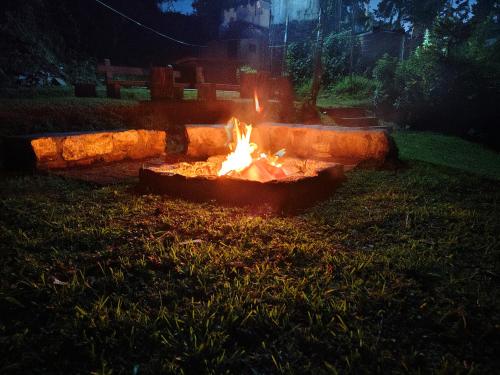 a fire pit in the grass in a yard at night at 7 ROADS RESORT 50mts to lake in Kodaikānāl