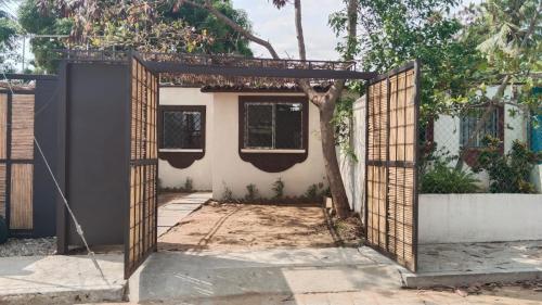 ein offenes Tor zu einem Haus mit einem Baum in der Unterkunft Encantador departamento a solo 7 minutos caminando de la playa in Puerto Escondido