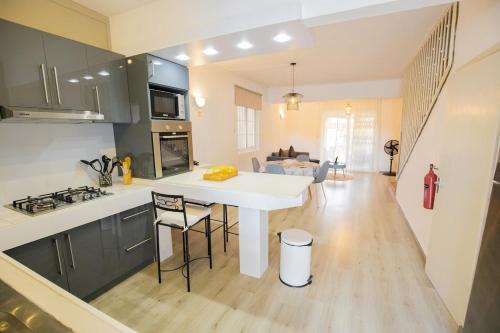 a kitchen and living room with a white table and chairs at Résidence du Récif - Le Perroquet in Bain Boeuf