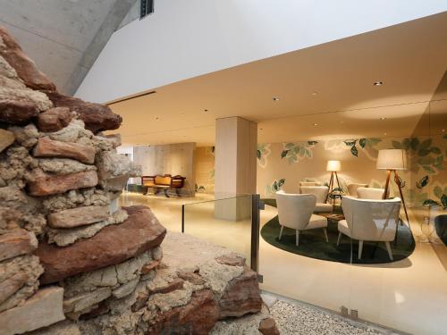 a room with a stone wall and a living room at Montebelo Vista Alegre Ílhavo Hotel in Ílhavo