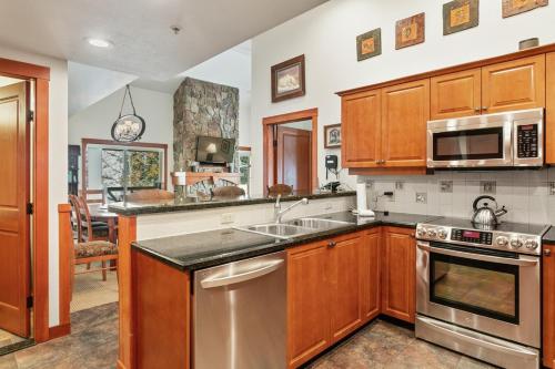 une cuisine avec des armoires en bois et des appareils en acier inoxydable dans l'établissement 1311 - Three Bedroom Deluxe Eagle Springs West condo, à Solitude