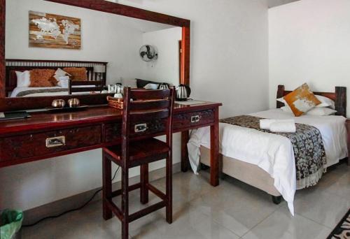 a bedroom with a desk with a bed and a desk sidx sidx sidx at Palm Afrique Lodge in Ghanzi