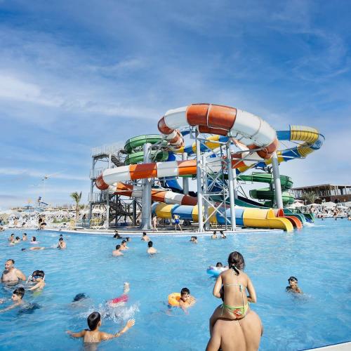 a group of people in the water at a water park at Sea Breeze Resort, Beachfront apartment with a balcony and sea view in Nardaran