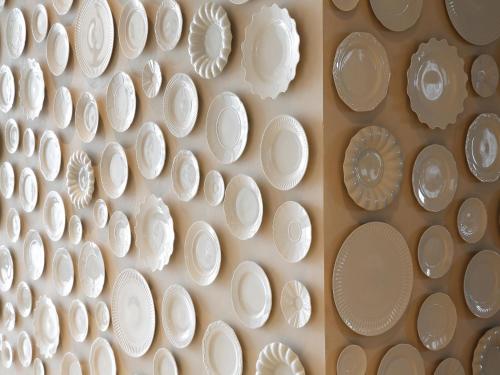 a wall full of white plates on a wall at Montebelo Vista Alegre Ílhavo Hotel in Ílhavo