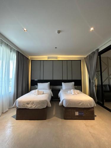 a bedroom with two beds with white sheets at SixtyFifth Destination Resort Hotel in Bacolod