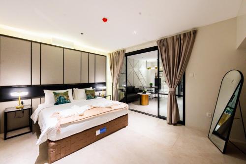 a bedroom with a large bed and a living room at SixtyFifth Destination Resort Hotel in Bacolod