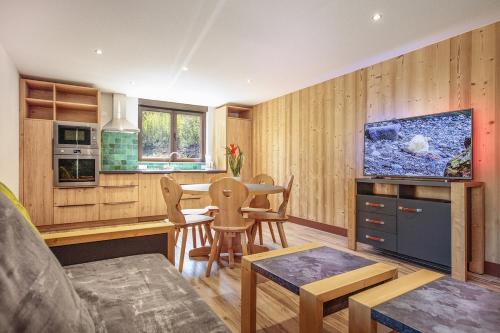 un salon avec une cuisine avec un aquarium sur le mur dans l'établissement Perce neige, à Morillon