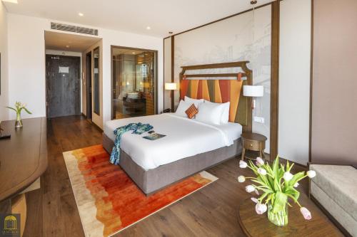 a bedroom with a bed and a living room at Apec Mandala Wyndham Mui Ne Ngoc Linh in Mui Ne
