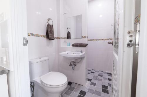 Un baño blanco con inodoro y lavabo. en Maderla house, en Pak Thong Chai