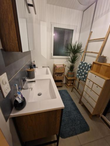 La salle de bains est pourvue d'un lavabo blanc. dans l'établissement Anna, Maison, Wifi, Jardin, 3couchages, Cocon charmant, Coup de coeur, à Puilboreau