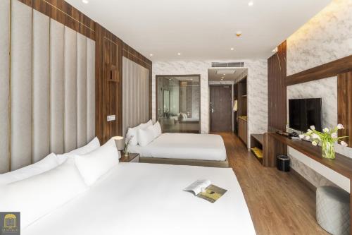 a hotel room with two beds and a television at Apec Mandala Wyndham Mui Ne Ngoc Linh in Mui Ne