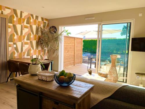 un salon avec une table avec un bol de fruits dessus dans l'établissement Sun Oasis Les Arrières Saisons, à Bretignolles-sur-Mer