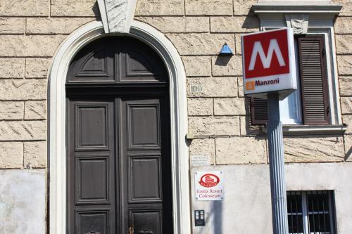 a black door with a sign next to a building at Roma Resort Colosseum in Rome