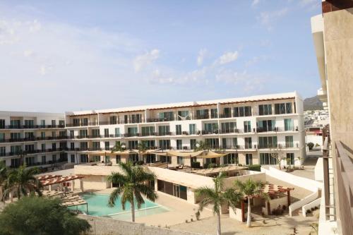a large white building with a pool and palm trees at Penthouse with panoramic terrace and pool in San José del Cabo