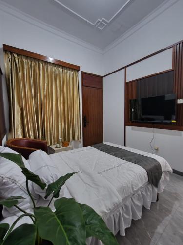 a bedroom with a large bed and a television at Domore Lifestyle in Jetis