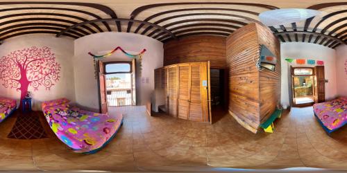 a room with two beds and a tree on the wall at Lele Room Downtown Querétaro in Querétaro