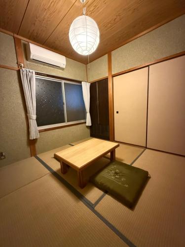 a room with a wooden table and a window at ゲストハウス 庵 Ann in Nachikatsuura
