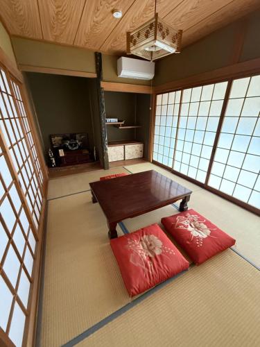 a room with a table and two red pillows at ゲストハウス 庵 Ann in Nachikatsuura