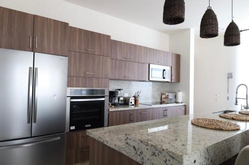 a kitchen with stainless steel appliances and a marble counter top at Penthouse with panoramic terrace and pool in San José del Cabo