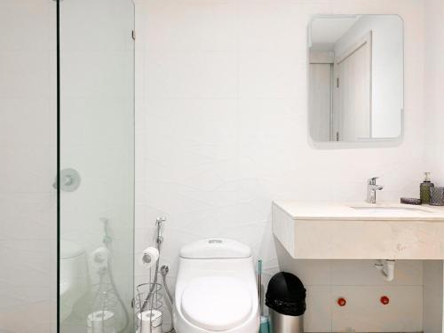 a bathroom with a toilet and a sink and a mirror at Airbnb Guayaquil, Mall del Sol, Piso alto in Guayaquil