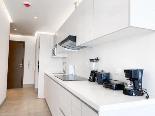 a kitchen with white cabinets and a counter top at Airbnb Guayaquil, Mall del Sol, Piso alto in Guayaquil