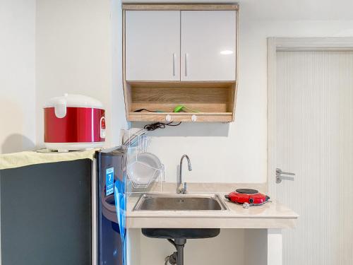 芝卡朗Good Place and Elegant 3BR Meikarta Apartment By Travelio的带水槽和冰箱的厨房