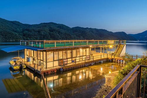 a dock with a building on the water at night at Gapyeong Garamseulki Pension in Gapyeong