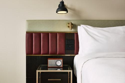 a bedroom with a bed and a clock on a night stand at Hotel Indigo Auckland by IHG in Auckland